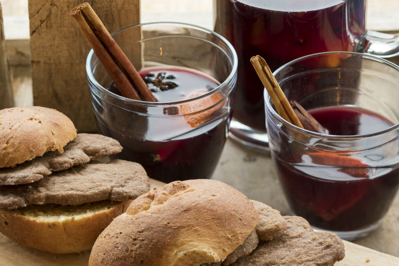 Broodjes gevuld met speculaasjes en glazen met bisschopswijn met kaneelstokjes