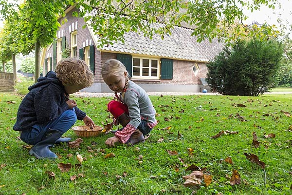 Twee kinderen in de tuin eikels aan het verzamelen
