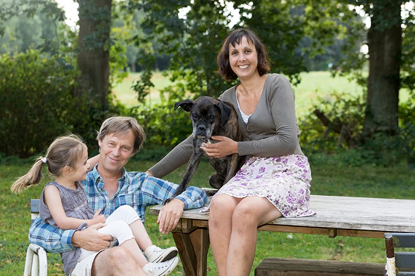 Een familie met de hond buiten op de picknickbank