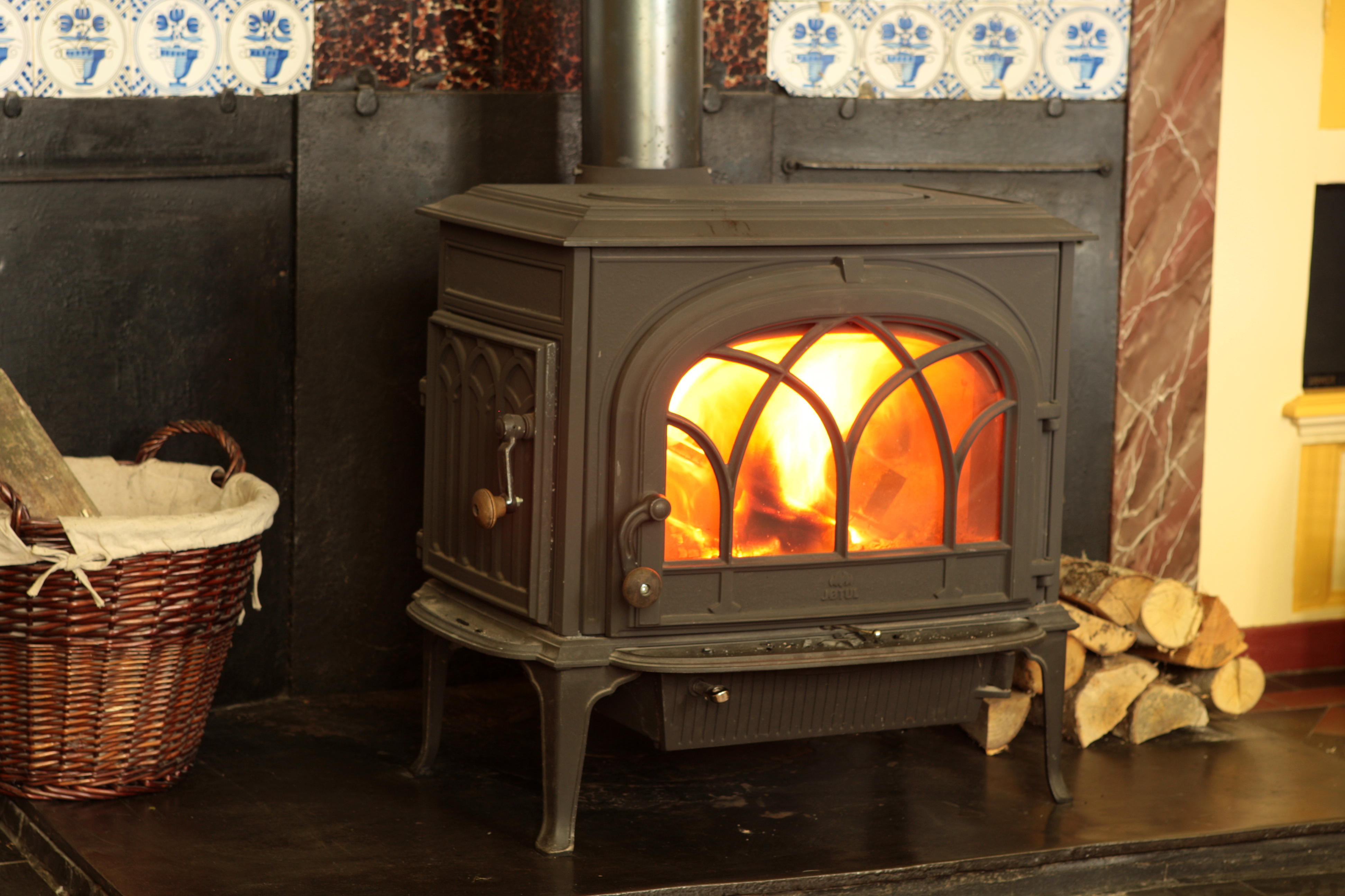 Houtkachel met een korf met houtblokken