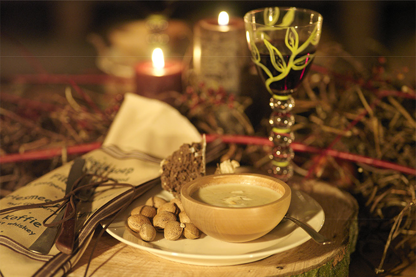 Knoflooksoep met een stukje brood op een bord met kaarsjes op de achtergrond 