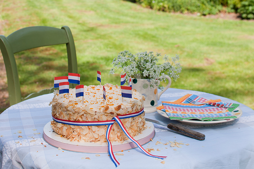 Een feestelijke taart met Nederlandse vlaggetjes er op voor Koningsdag