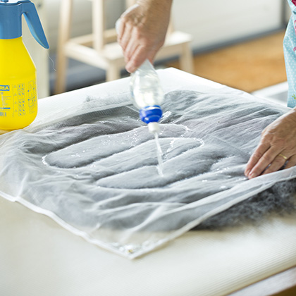 Ronde lap vilt op tafel bedek met wol en leg hierop vitrage