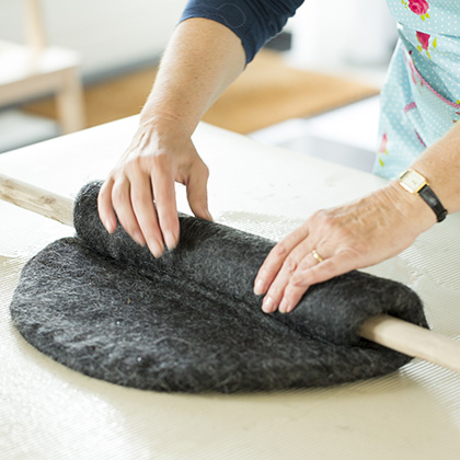 Ronde lap vilt op tafel bedek met wol en leg hierop vitrage