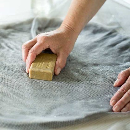 Ronde lap vilt op tafel bedek met wol en leg hierop vitrage
