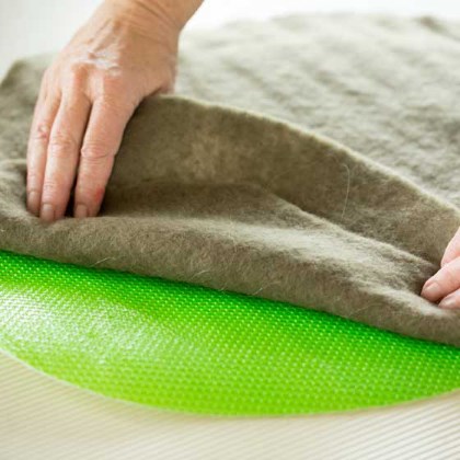 Ronde lap vilt op tafel bedek met wol en leg hierop vitrage