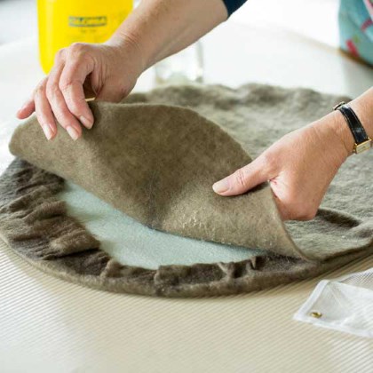 Ronde lap vilt op tafel bedek met wol en leg hierop vitrage