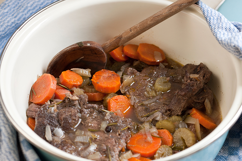 Draadjesvlees in een schaal met wortels en anderen groenten