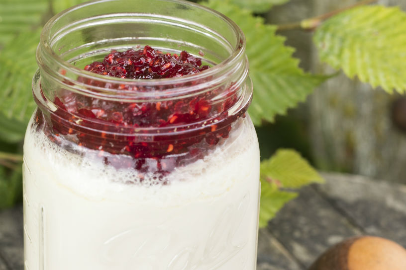 glazen pot gevuld met zelfgemaakte yoghurt met rode bessen