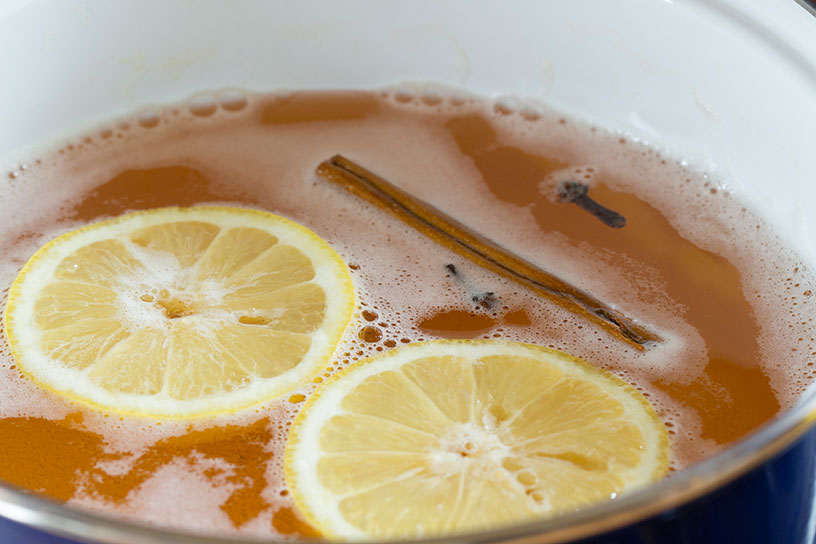 Zopie drankje met citroenschijfjes, kaneelstokjes en kruidnagel